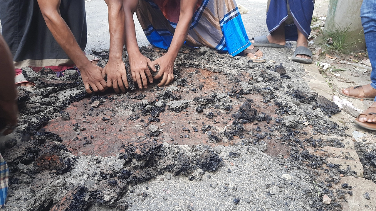 হাতের টানে উঠে আসছে রাস্তার কার্পেটিং। ছবি : কালবেলা