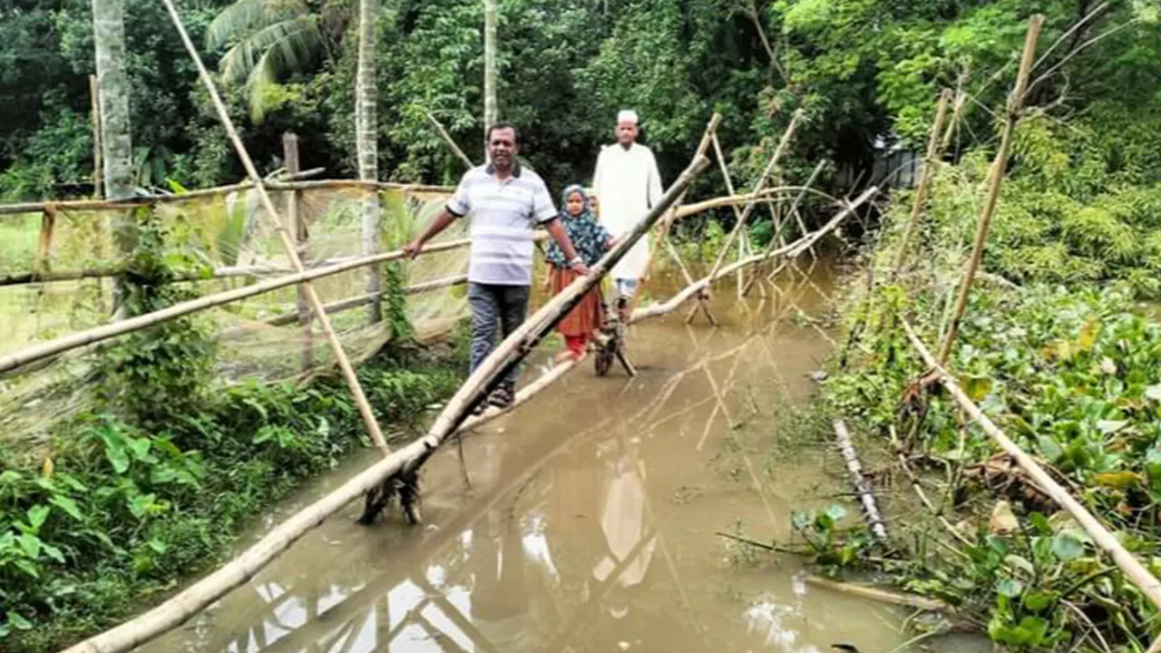 পাকা সড়ক পানিতে ডুবে যাওয়ায় ঝুঁকিপূর্ণ বাঁশের সাঁকো দিয়ে পারাপার হচ্ছেন গ্রামবাসী। ছবি : কালবেলা