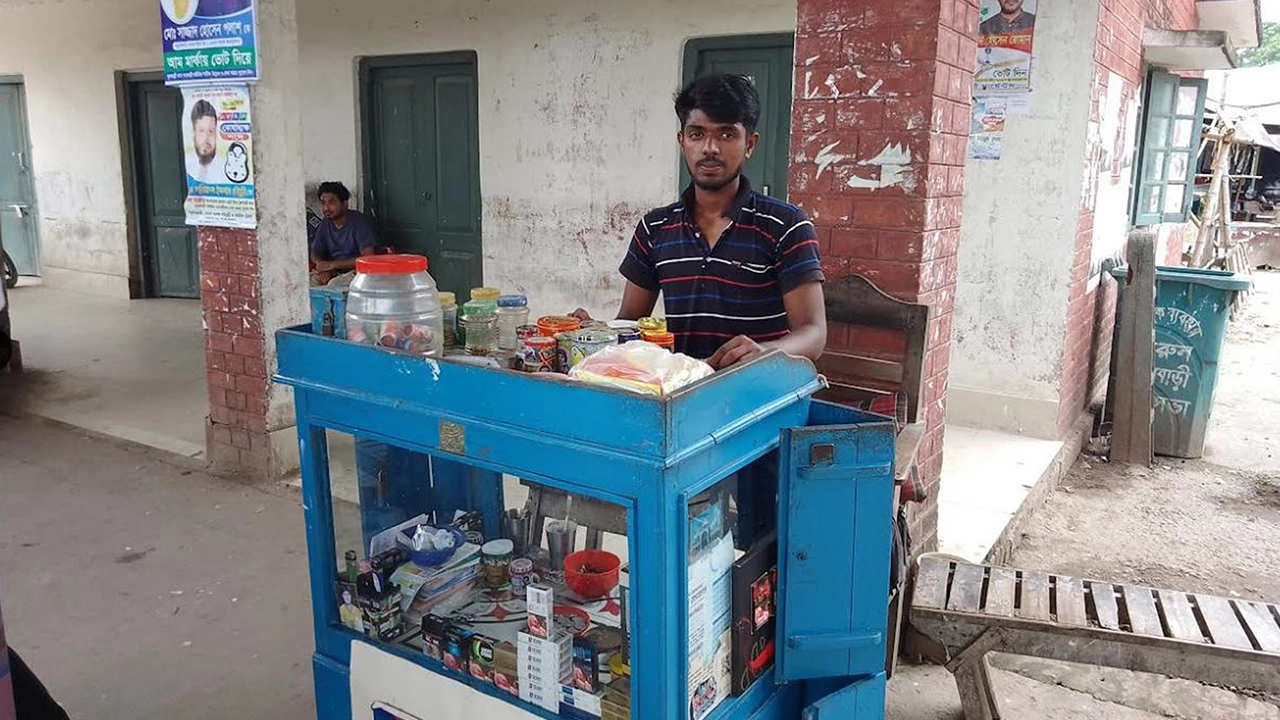 যাত্রীশূন্য ফুলবাড়ী রেলওয়ে স্টেশনে ঠায় দাঁড়িয়ে আছেন ক্ষুদ্র ব্যবসায়ী। ছবি : কালবেলা