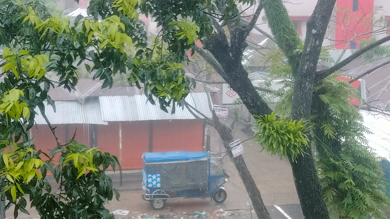 বৃষ্টির মধ্যে যাত্রীর জন্য বসে আছেন এক অটোচালক