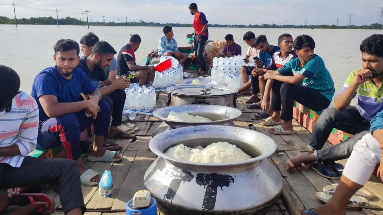 ‘জরুরি সেবা টিম’ বন্যাদুর্গত এলাকার বিভিন্নস্থানে রান্না করা খাবার বিতরণে করছে। ছবি : কালবেলা