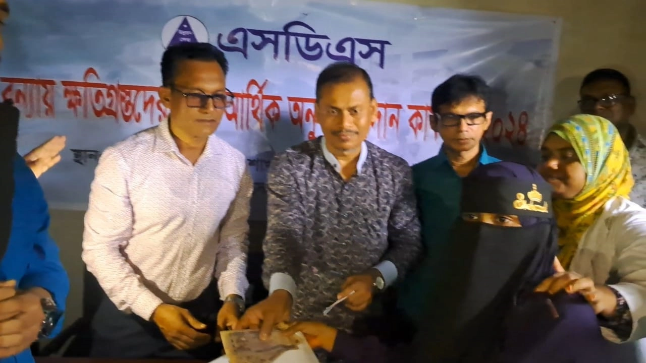 বন্যার্তদের মধ্যে নগদ অর্থ তুলে দেন এসডিএসের কর্মকর্তারা। ছবি : কালবেলা