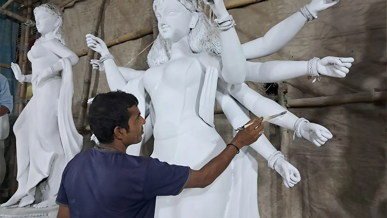 সাহাপাড়ায় মণ্ডপে রং তুলিতে দুর্গা প্রতিমা সাজানোর কাজ করছেন কারিগর নরেশ চন্দ্র। ছবি : কালবেলা
