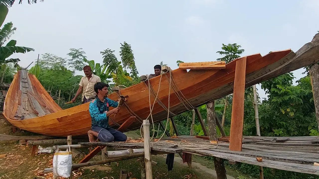 সাতক্ষীরার পাটকেলঘাটে নৌকা তৈরিতে ব্যস্ত এক কারিগর। ছবি : কালবেলা