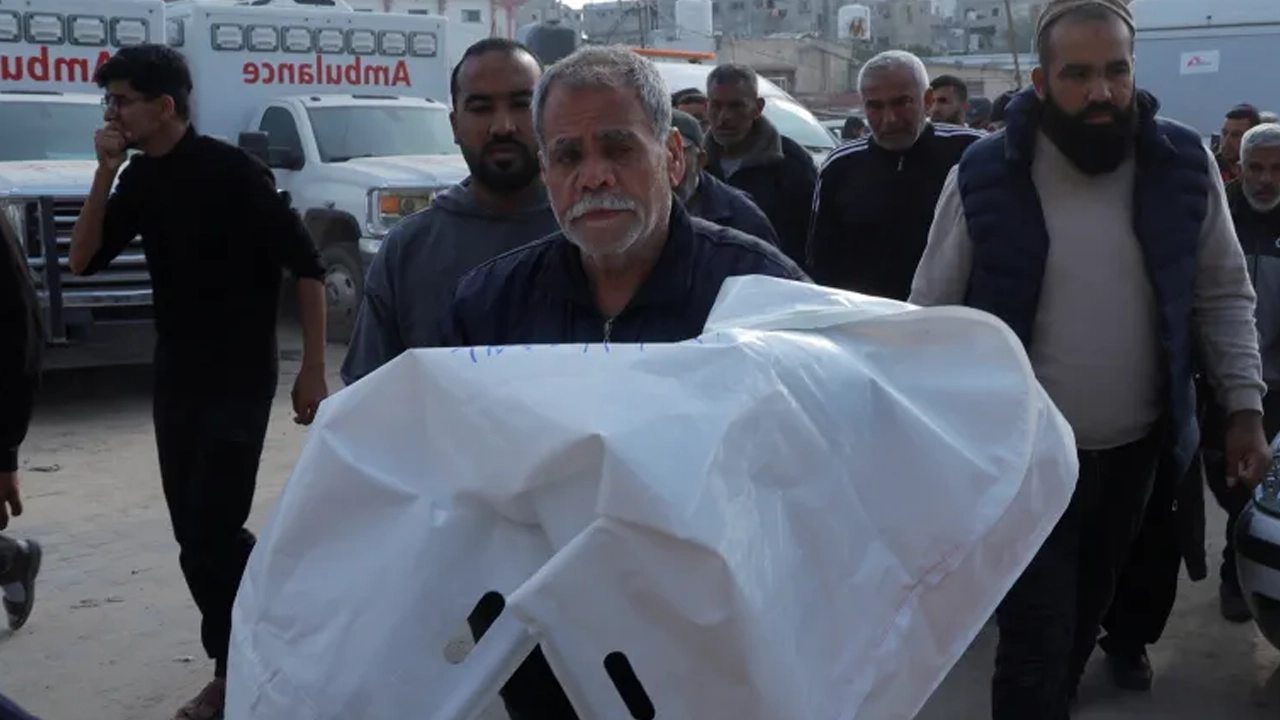 ইসরায়েলি হামলায় নিহত শিশুর মরদেহ নিয়ে যাচ্ছেন এক ব্যক্তি। ছবি: রয়টার্স