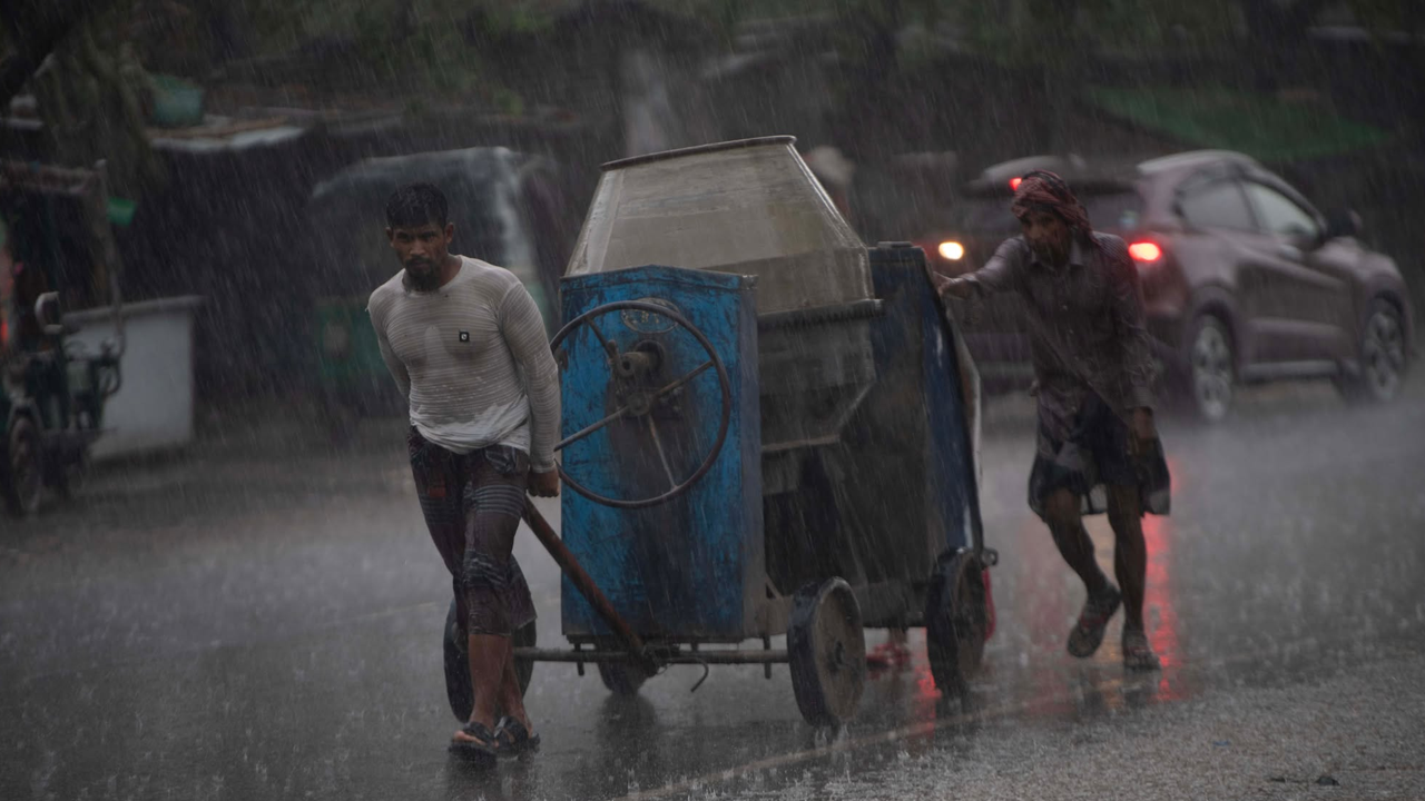 বৃষ্টির মধ্যে কাজে যাচ্ছেন শ্রমিকরা। ছবি : সংগৃহীত