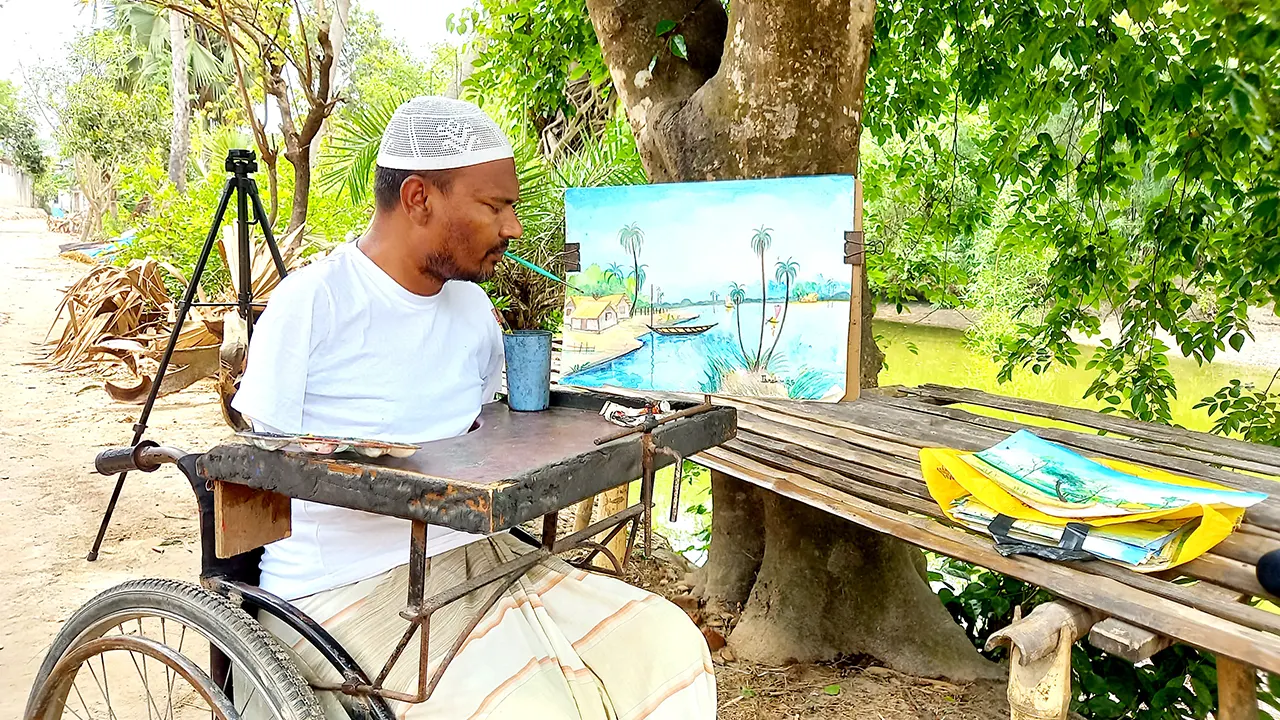 দুর্ঘটনায় হাত-পা অচল হওয়ায় ক্যানভাসে মুখ দিয়ে তুলি ধরে ছবি আঁকেন ইব্রাহিম। ছবি : কালবেলা