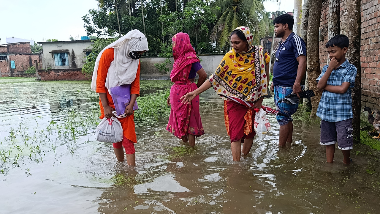 পানি ডিঙিয়ে পরীক্ষা দিতে যান শিক্ষার্থী। ছবি : কালবেলা