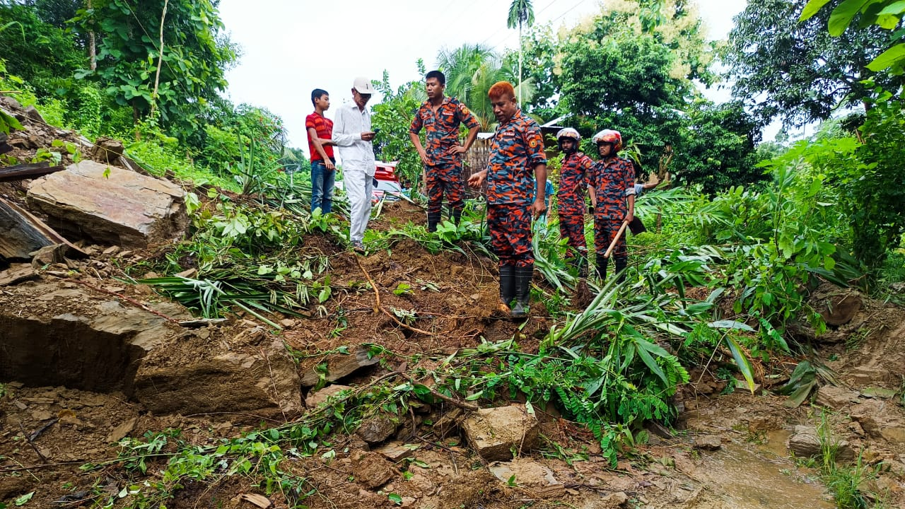 রাস্তা থেকে মাটি সরানোর কাজ শুরু করেছেন ফায়ার সার্ভিসের কর্মীরা। ছবি : কালবেলা