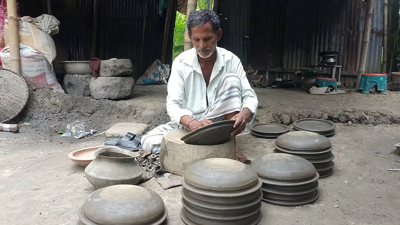 কাদামাটি দিয়ে মাটির নানারকম পণ্য তৈরি করছেন মৃৎশিল্পী ঈশ্বর চন্দ্র পাল। ছবি : কালবেলা