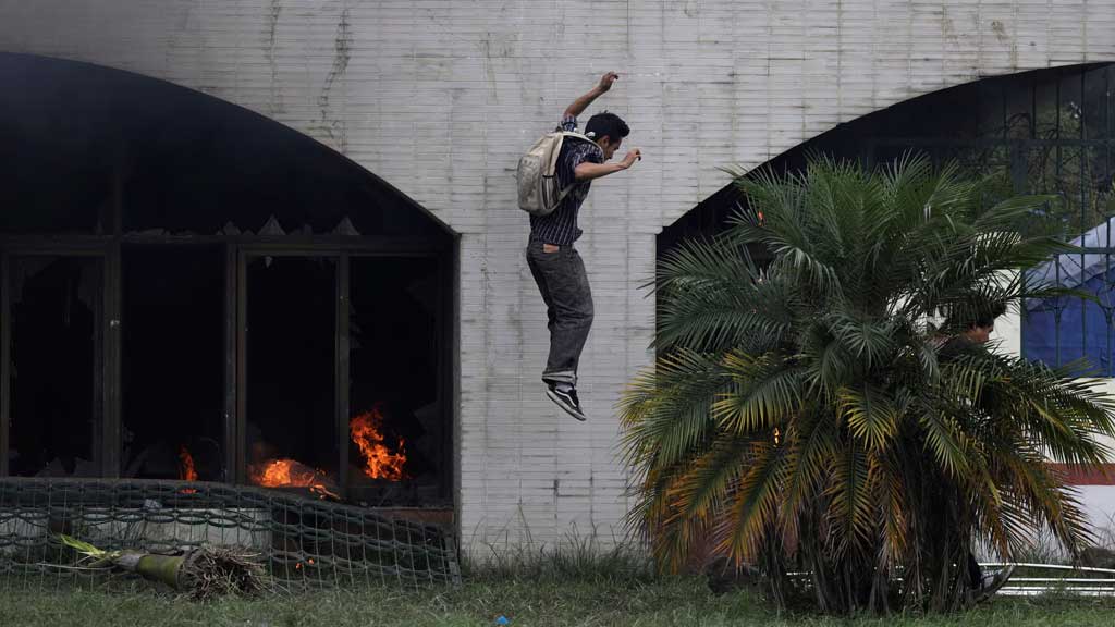 জেন-জি আন্দোলনে নেপালে সরকার পতন ঘটে। ৮ সেপ্টেম্বর রাজধানী কাঠমান্ডুতে বিক্ষোভ চলার সময় পার্লামেন্ট ভবন থেকে লাফিয়ে নামছে এক বিক্ষোভকারী।